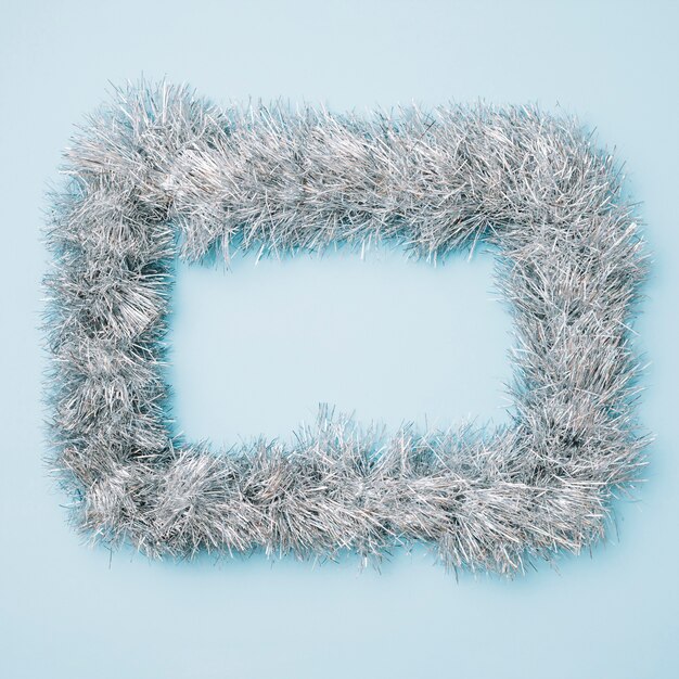 grey frame from tinsel on blue table