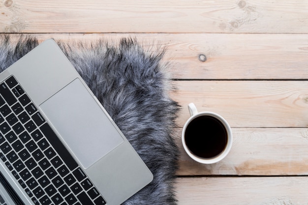 Grey laptop with coffee on wood table