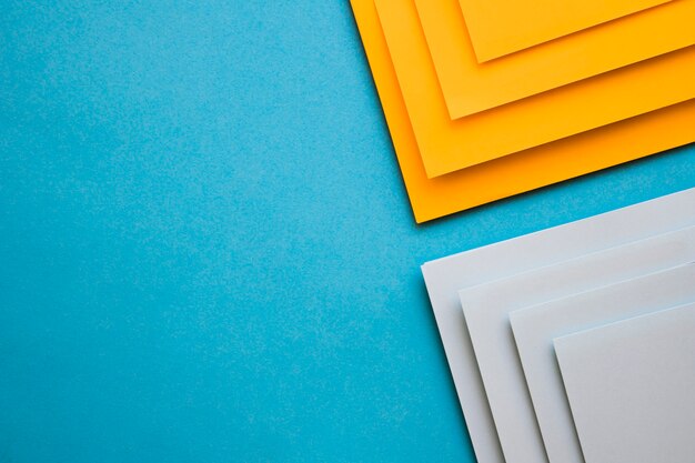 Grey and yellow cardboard papers on blue background