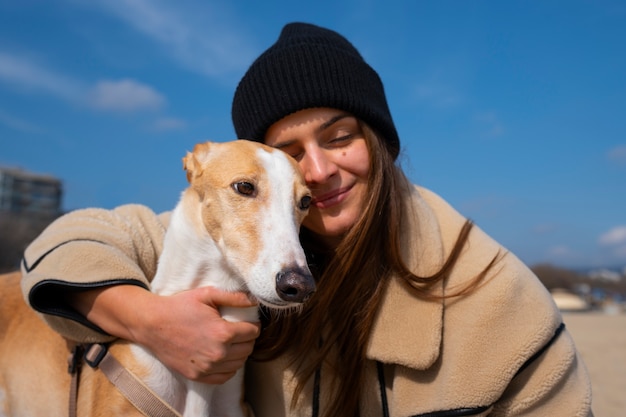 無料写真 ビーチで女性の所有者とグレイハウンド犬