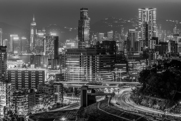 Greyscale shot of the beautiful city lights and buildings captured at night in Hong Kong