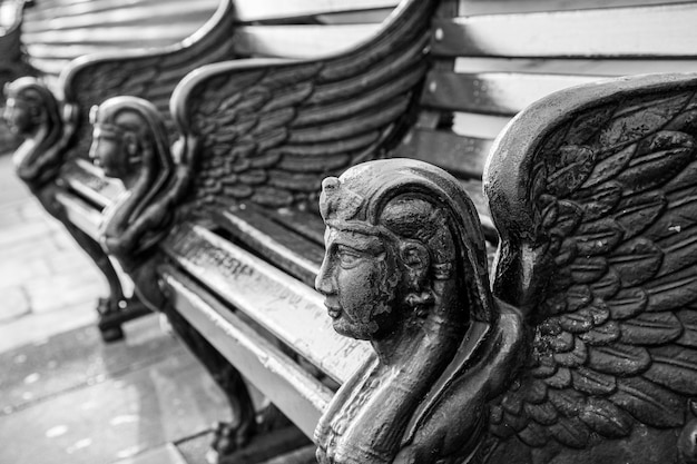 Greyscale shot of the beautifully decorated stone benches captured in London, England