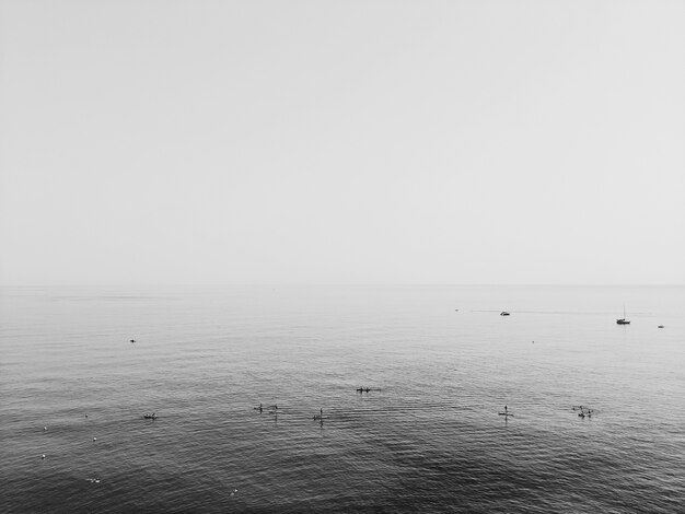 Greyscale shot of the ocean under a clouded sky