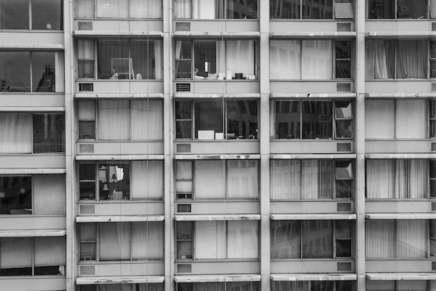 Greyscale shot of an old building with wide windows