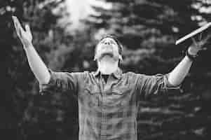 Free photo greyscale shot of a young male looking up with his arms open