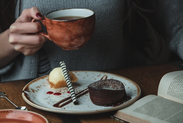 チョコレートフォンデュとコーヒーのカップを保持しているグリル