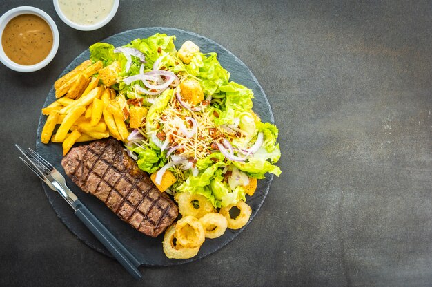 Grilled beef meat steak with french fries onion ring 