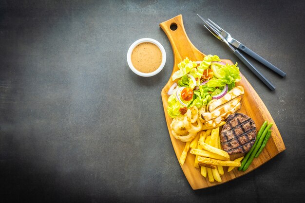 Grilled beef meat steak with french fries sauce and fresh vegetable