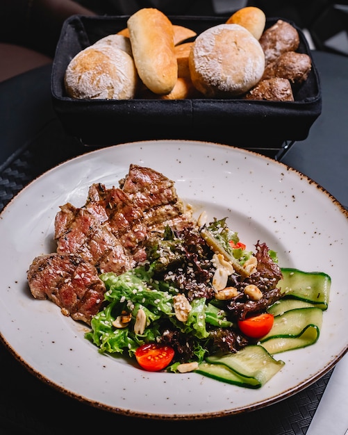 Free photo grilled beef salad with lettuce cucumber tomato sesame and pistachio