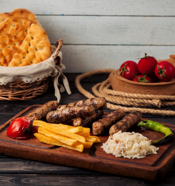 grilled beef sausages with rice, french fries, pepper and tomato