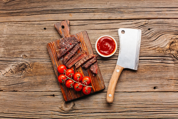 커팅 보드에 신선한 토마토 소스와 구운 쇠고기 스테이크