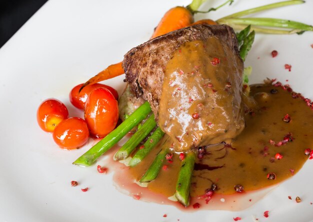 Grilled beef tenderloin with asparagus and tomato in red wine sa