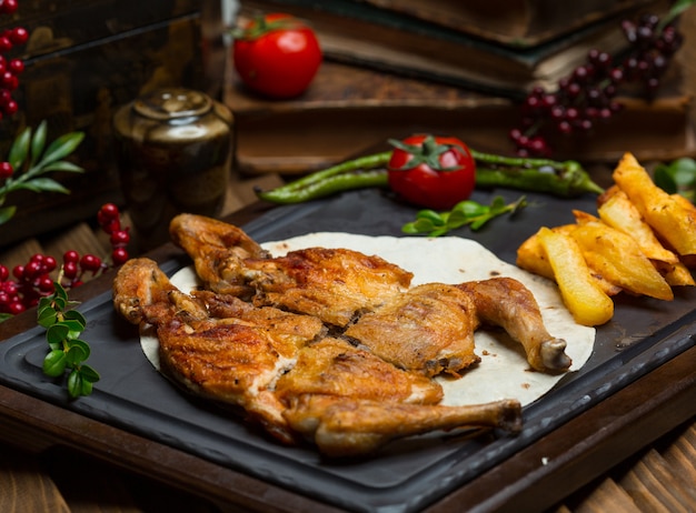 Grilled chicked with roasted potatoes in lavash on a stone board