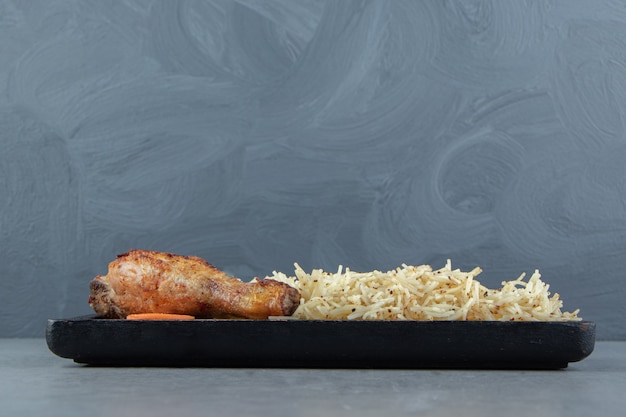 Foto gratuita coscia di pollo alla griglia e pasta di pollo su banda nera.