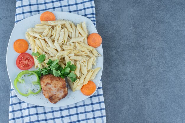 Free photo grilled chicken and creamy penne on white plate.