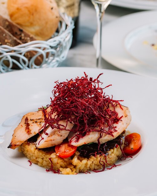 Grilled chicken fillet served with bulgur and vegetables