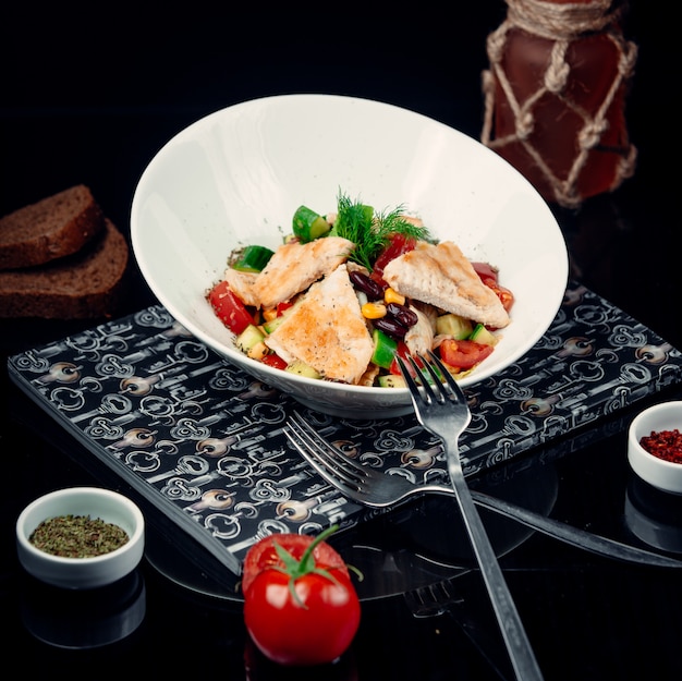 Бесплатное фото Куриное филе на гриле с овощным салатом в белой миске.