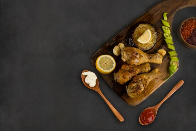 Grilled chicken legs served with lemon, chili and sauces