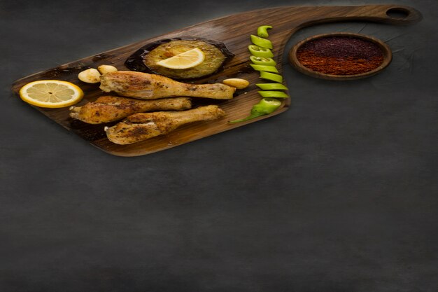 Grilled chicken legs served with lemon, chili and sauces