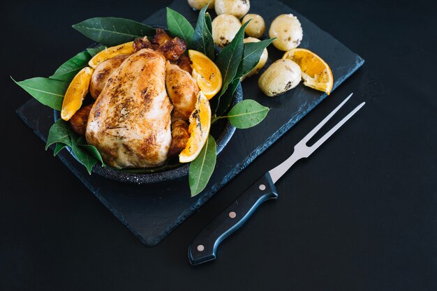 Grilled chicken near fork and boiled potatoes