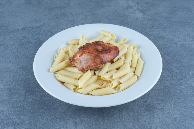 Жареный цыпленок и макаронные изделия пенне в белом шаре.