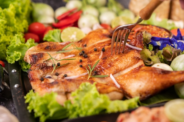 Grilled chicken on the plate with chili Garlic and sprinkled with pepper seeds.