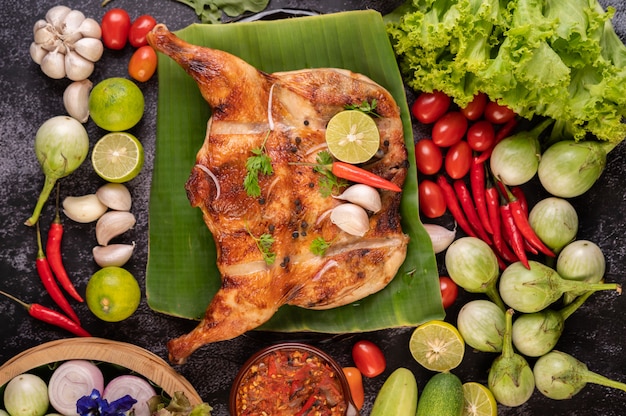 grilled chicken on a plate with chili peppers, garlic sauce and sprinkled with pepper seeds.