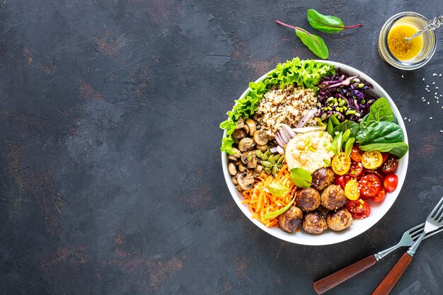 Grilled chicken, rice, spicy chickpeas, avocado, cabbage, pepper buddha bowl on dark, top view.