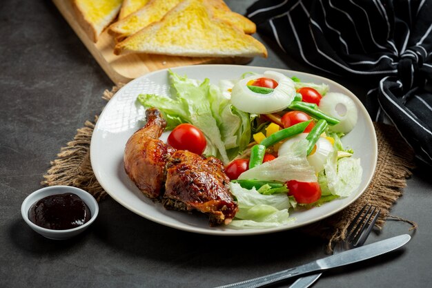 Grilled chicken steak and vegetables on dark background