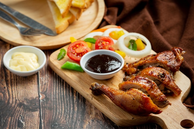 Grilled chicken steak and vegetables on dark wood background