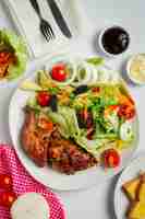 Free photo grilled chicken steak and vegetables on marble background