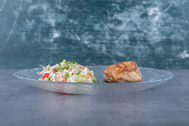 Grilled chicken and vegetable salad on glass plate.