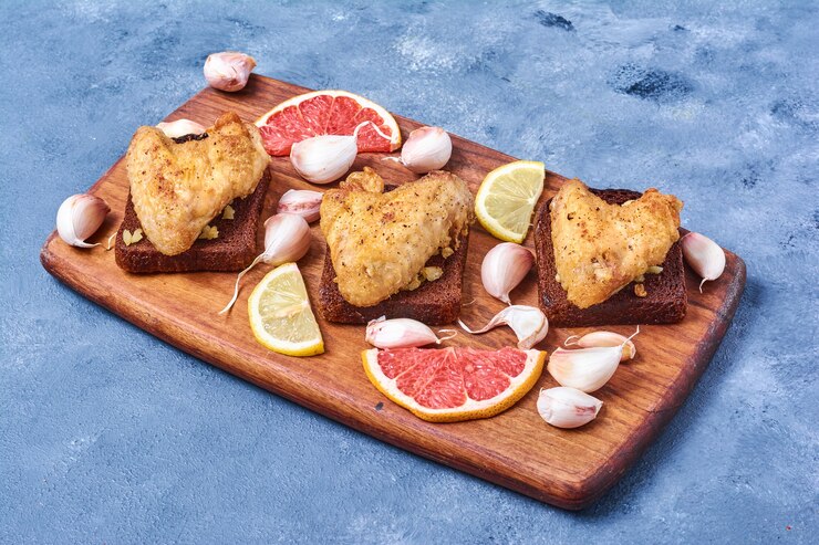 Free Photo grilled chicken wings with spices on a wooden board on blue