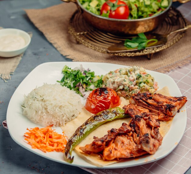 Grilled chicken with salad, rice, tomato and green chili.