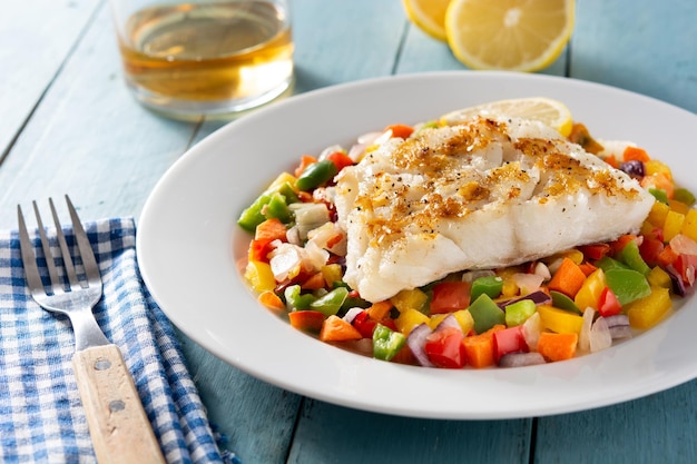 Free photo grilled cod with vegetables on blue wooden table