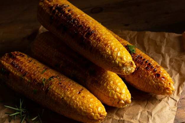 Grilled corn cobs on wood background.