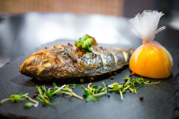 Grilled fish close up decorated with vegetables