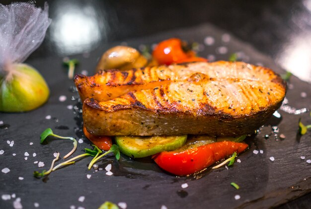 Grilled fish close up decorated with vegetables