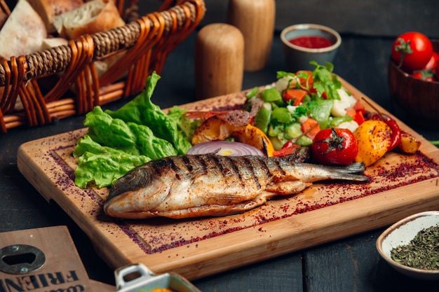 Бесплатное фото Рыба на гриле с салатом из свежих овощей, листьями салата и сумах