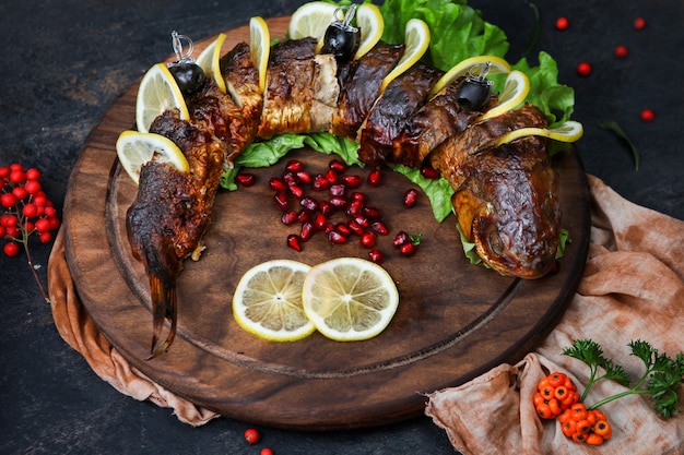 Free photo grilled fish with herbs, fruits, lemon