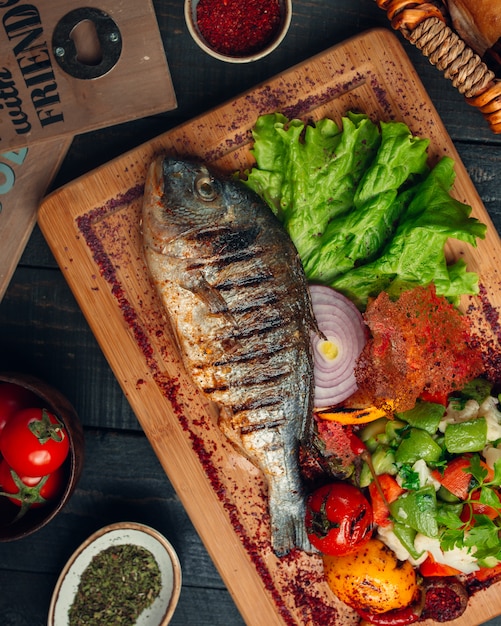 рыба на гриле с овощным салатом, луком и сумах