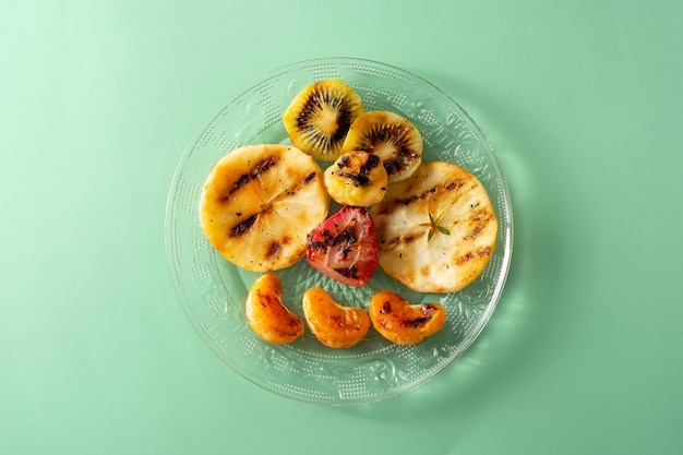 Grilled fruit for summer on green background