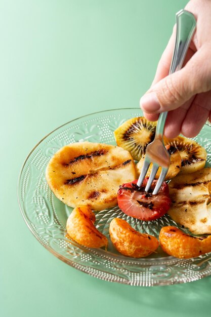 Grilled fruit for summer on green background