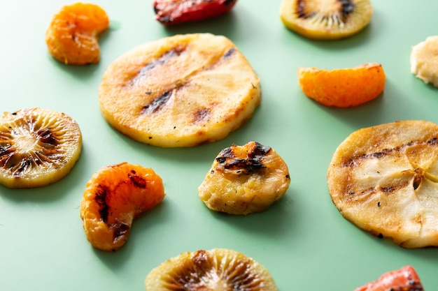 Grilled fruit for summer on green background