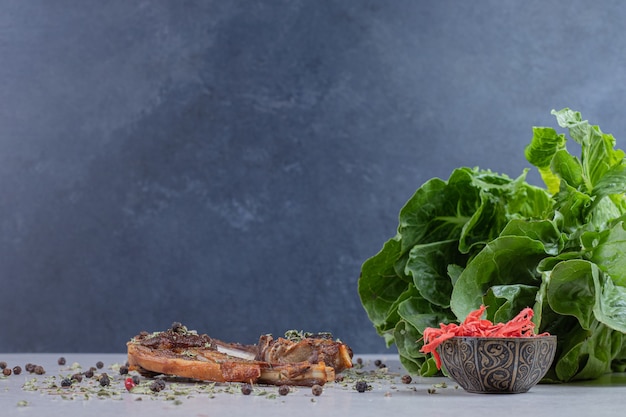 Grilled lamb chops on white background with lettuce and ginger.