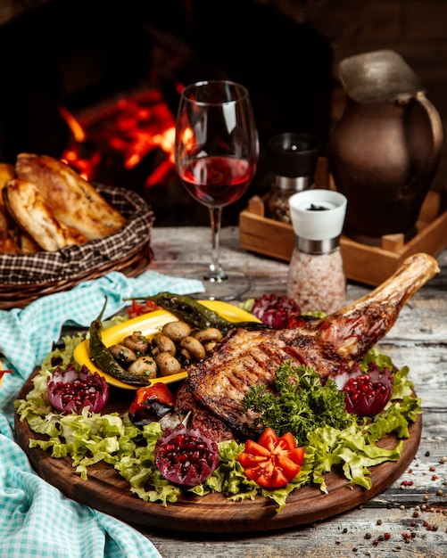 Coscia di agnello alla griglia con verdure e vino vista laterale