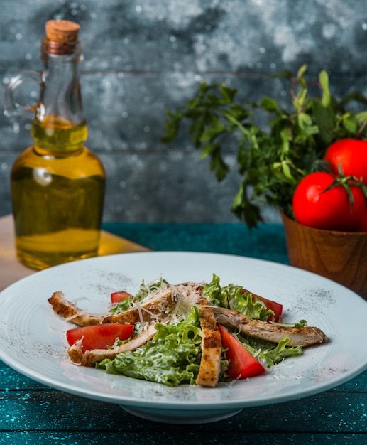 Foto gratuita bastoncini di agnello alla griglia con lattuga, fettine di pomodoro, formaggio in salsa