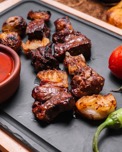 Grilled lamb tomato pepper potato sauces side view