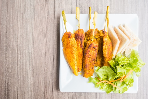 Grilled meat barbecue on a wooden stick seen from above