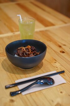 나무 테이블 배경으로 일본 쌀에 구운 고기.